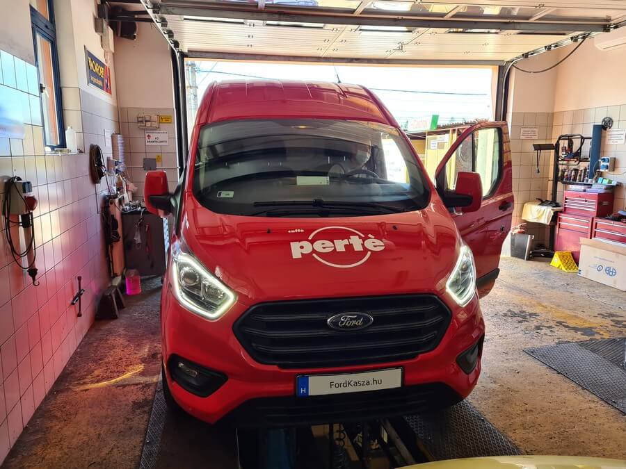 Piros Ford Transit Custom az emelőn a műhelyben