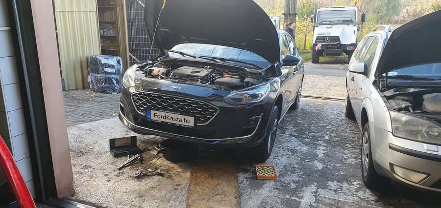 Ford személyautó a szervizben, nyitott motortérrel